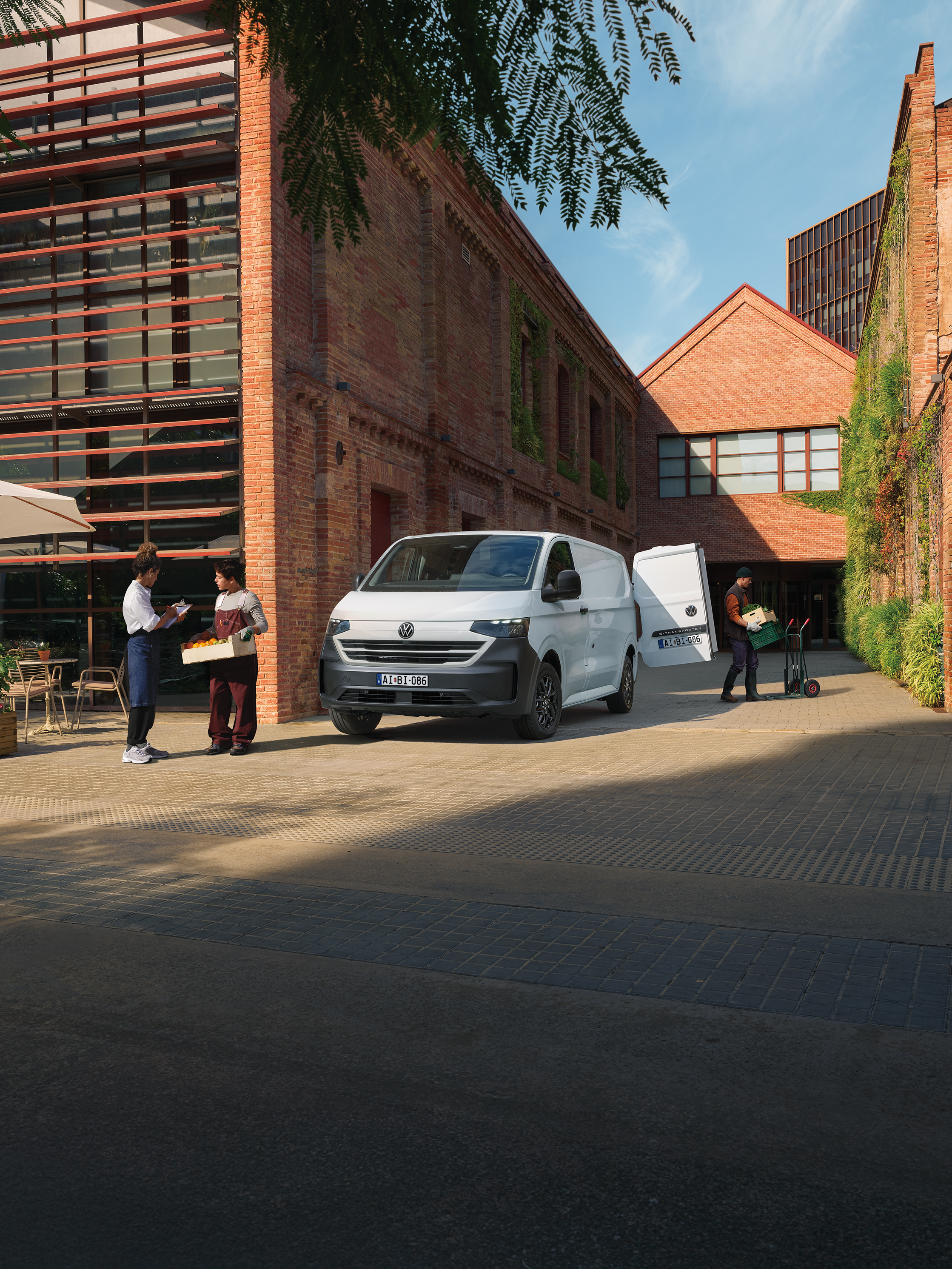 VW Transporterből pakol ki a postás egy kellmes utcán