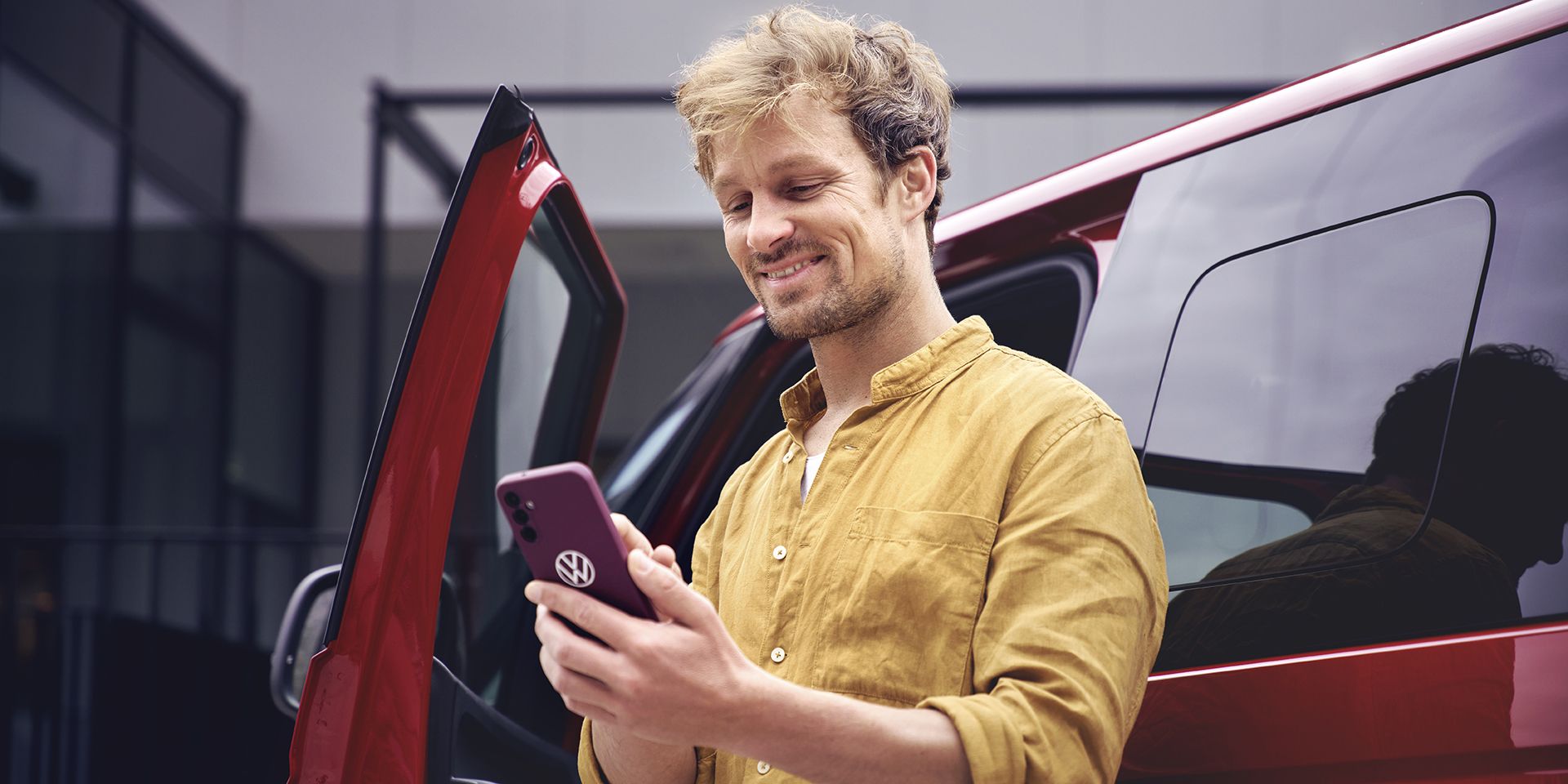 mosolygó férfi nézi a telefonját