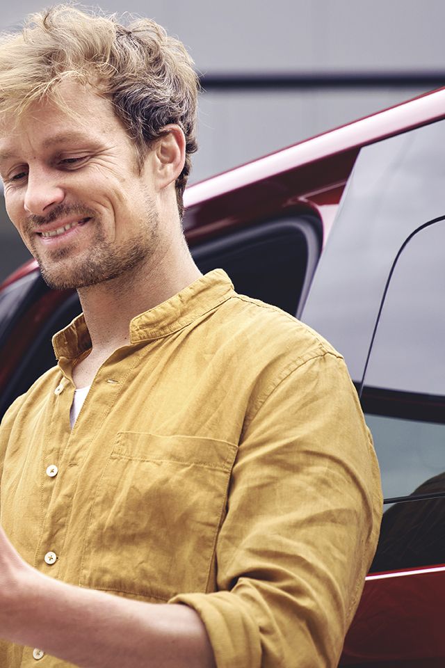 mosolygó férfi nézi a telefonját