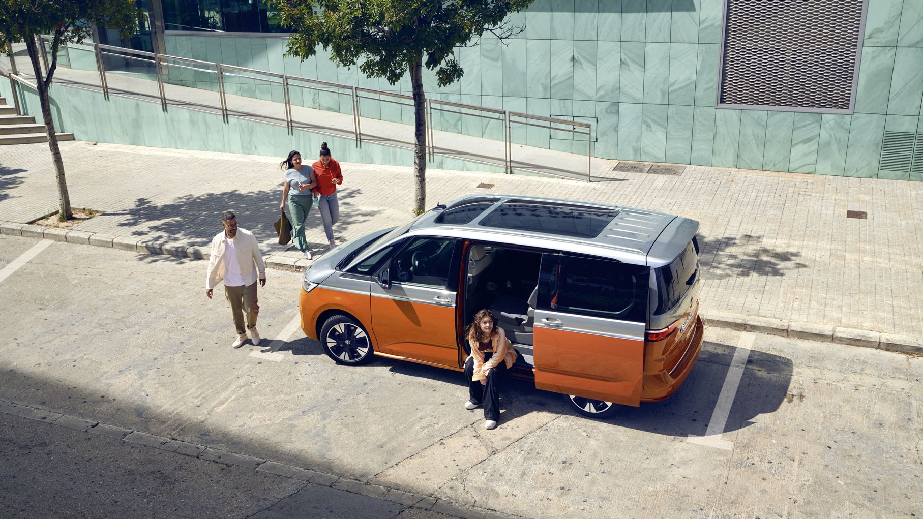 Der neue VW Multivan T7 2021 Energetic steht mit geöffneter Schiebetür am Ufer.