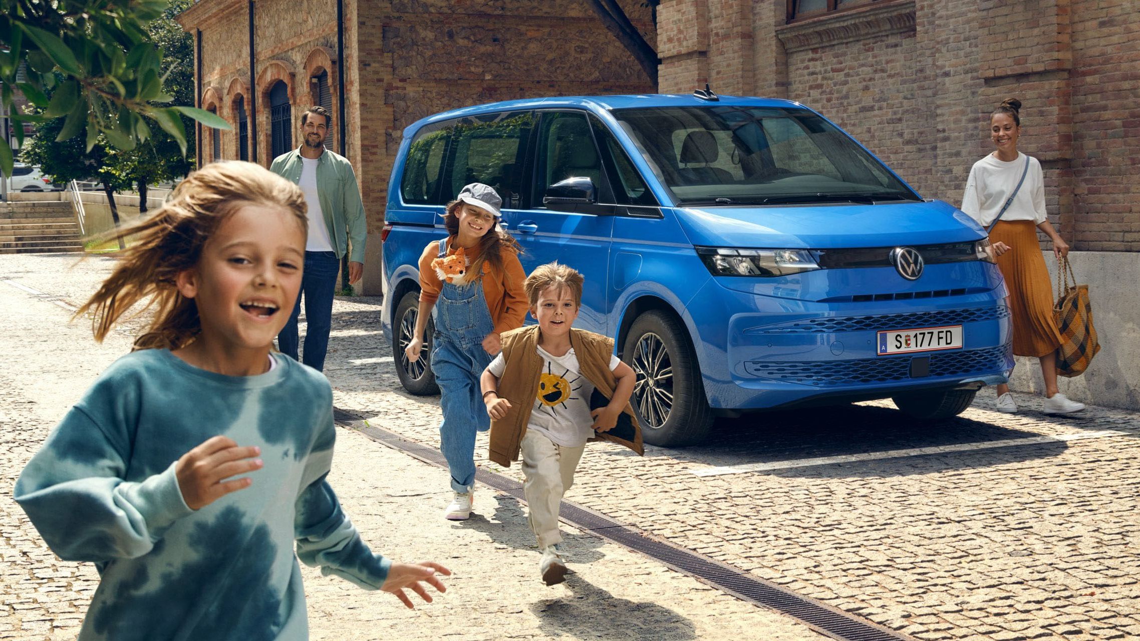 Gyerekek az új VW Multivan T7 2021 mellett futnak.