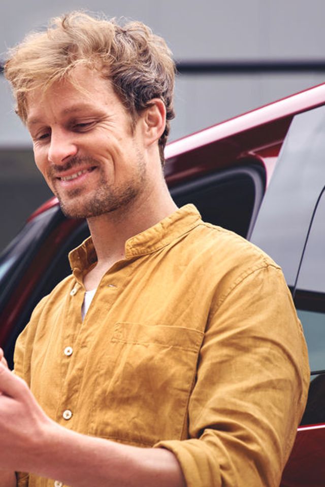 Férfi VW logós mobiltelefont fog a kezében