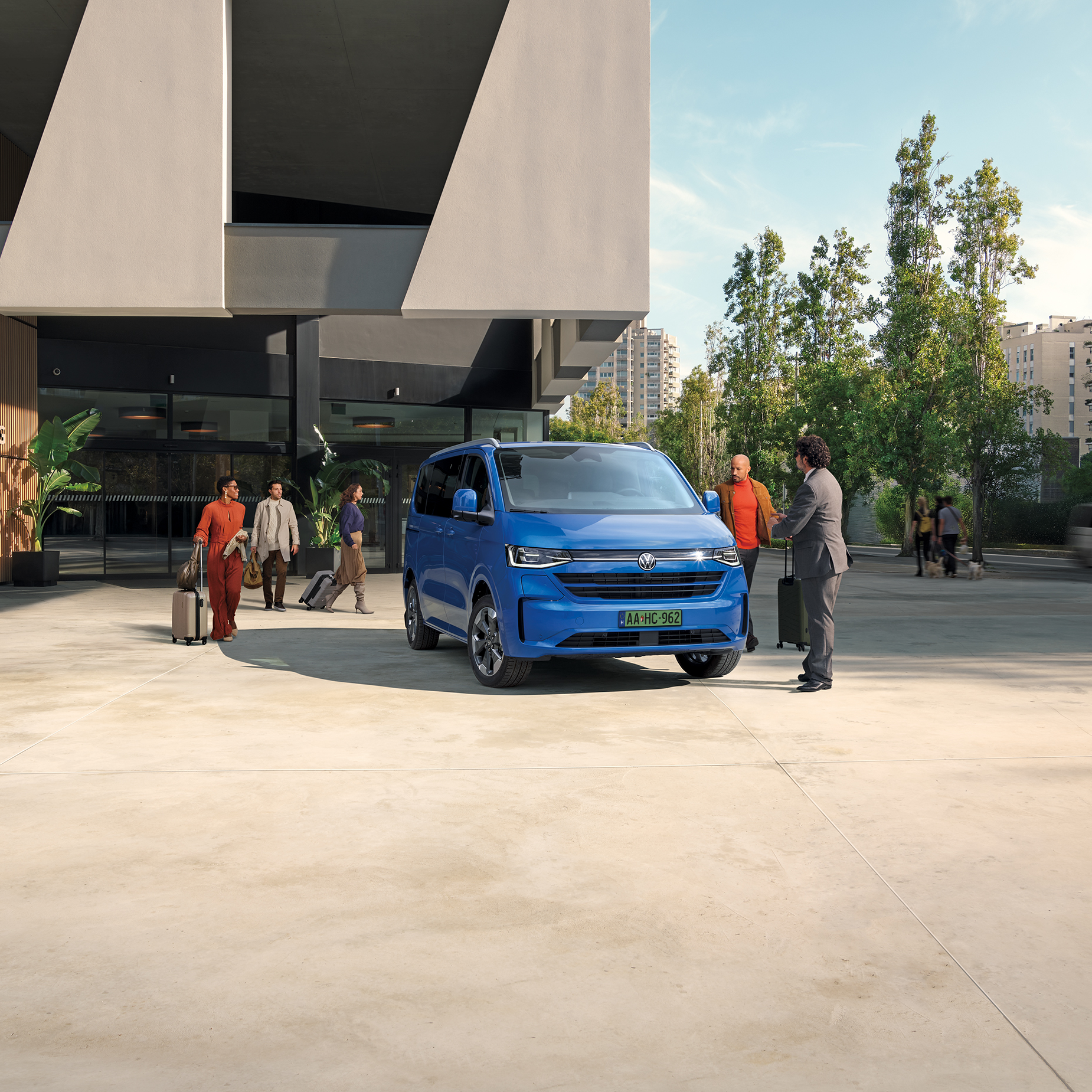 Kék VW Caravelle körülötte emberek 